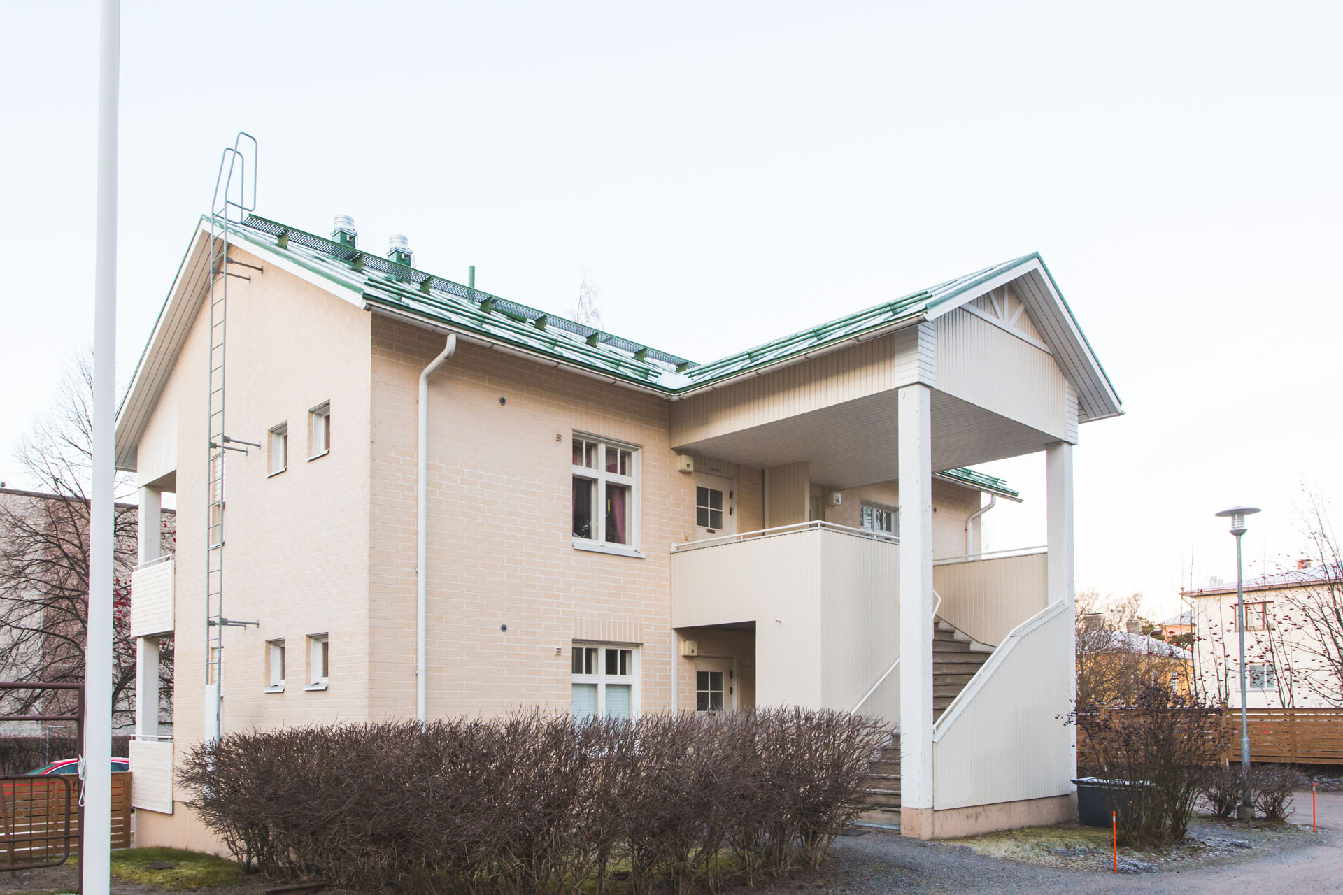 Kaksikerroksinen beigenvärinen pienkerrostalo, Setlementti Messi. Talossa on vuokra-asuntoja työssäkäyville nuorille.